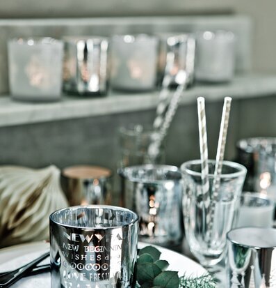 Bild av stämningsfullt dukat bord med ljuslyktor och glas