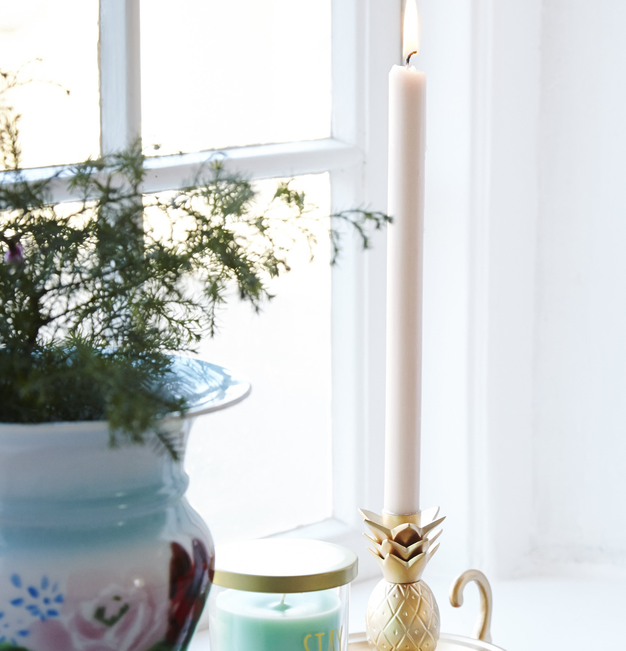 Ljusstake Pineapple Gold från Rice på en fönsterbräda