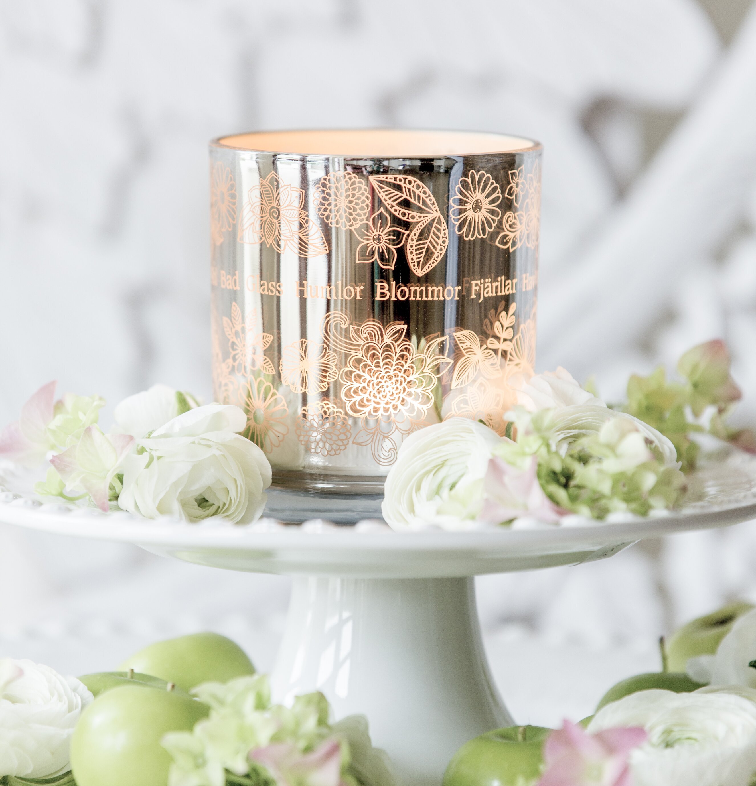 Foto av somrig ljuslykta med blommönster och äpplen