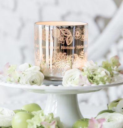 Foto av somrig ljuslykta med blommönster och äpplen