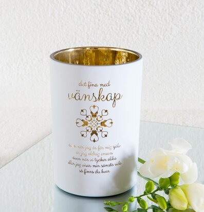 Bild av ljuslykta med gyllene design och vit finish