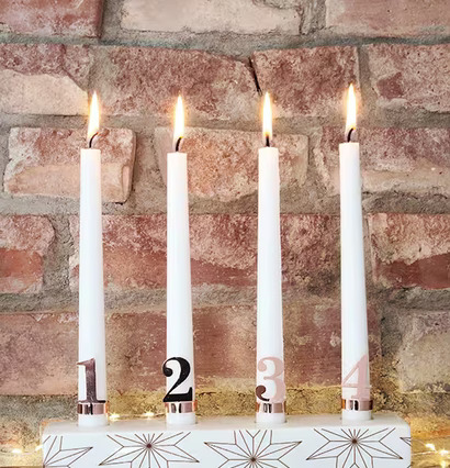 Bild av adventsljusstake mot rustik tegelvägg