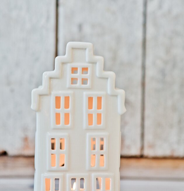 Bild av dekorativ ljuslykta i husform med varm glöd