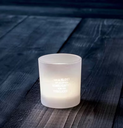 Bild av ljuslykta i frostat glas på rustik träyta