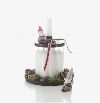 Bild av ljusstake med tomtar och naturliga element