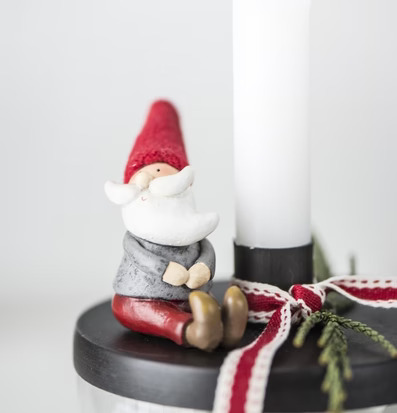 Foto av elegant ljusstake med tomte och dekorativa band