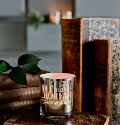 Foto av stilren ljuslykta på böcker i hemtrevlig miljö