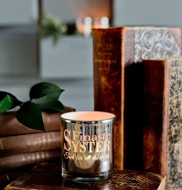 Bild av elegant arrangemang med ljuslykta och böcker