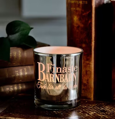 Bild av elegant ljuslykta med antika böcker och växt