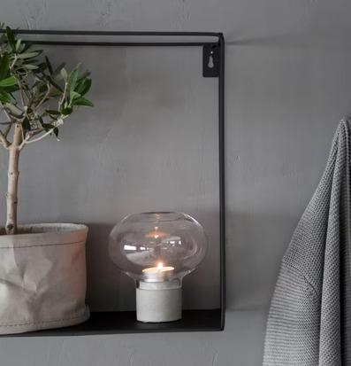 Bild av harmonisk inomhusmiljö med ljusstake och olivträd