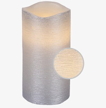 Bild av silverfärgat vaxljus med vågig överkant